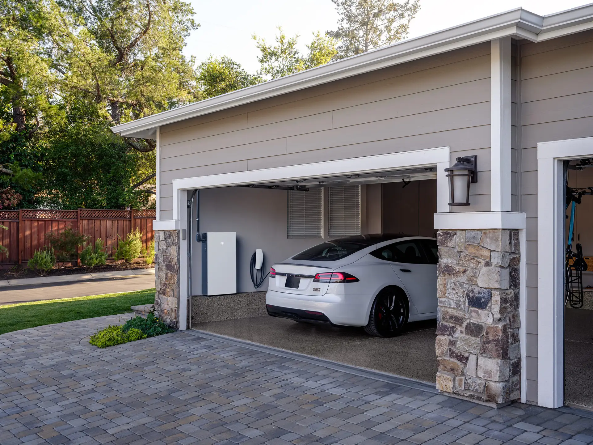 Home garage with wall-mounted battery storage units and an electric car