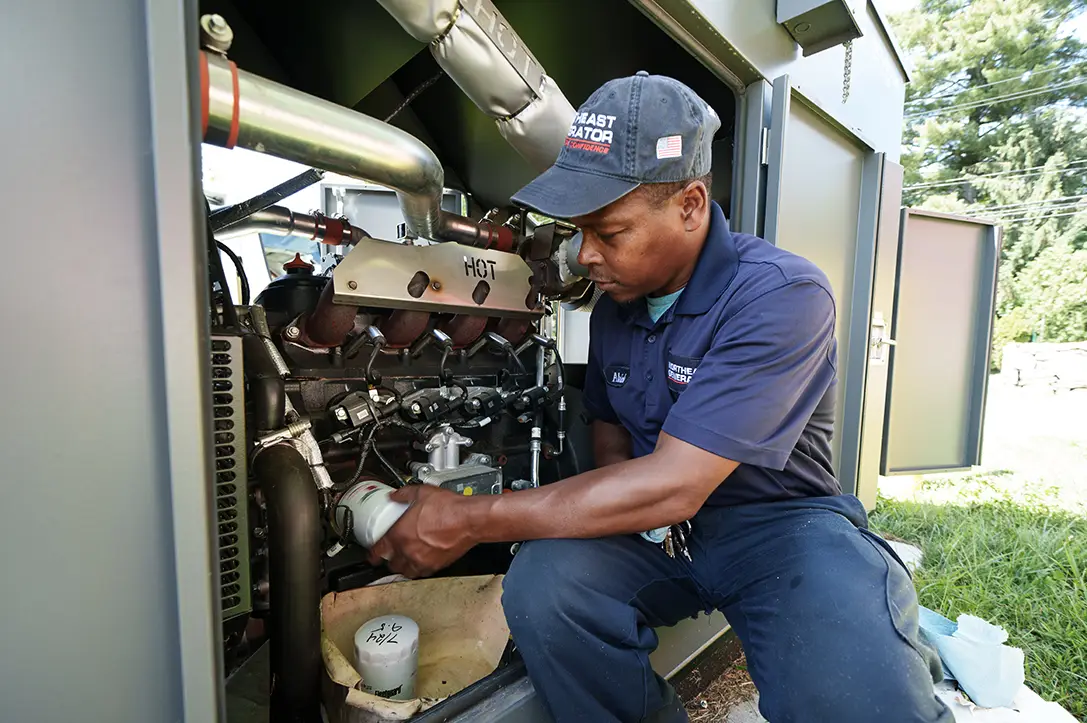 Technician servicing the engine of a commercial generator