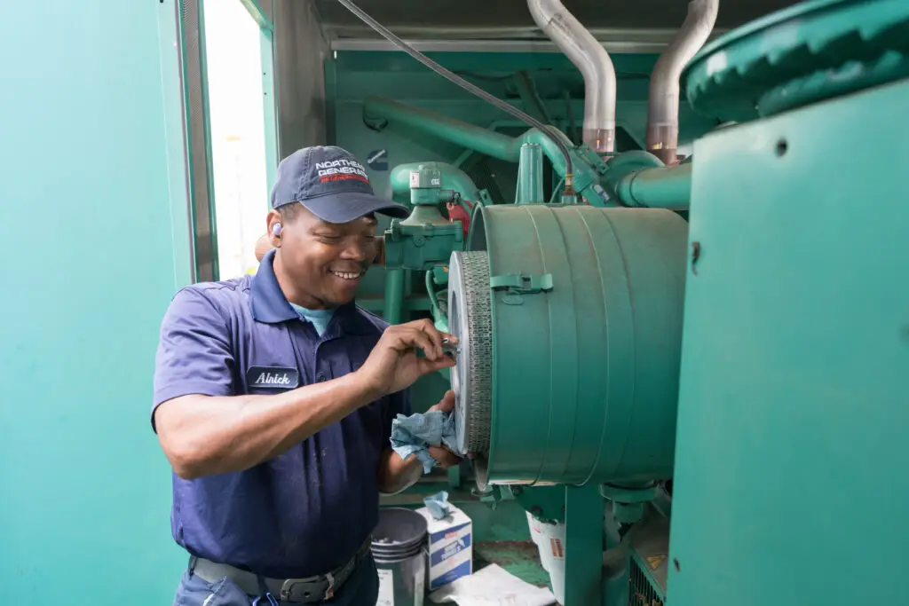 Northeast Generator technician servicing the air filter housing on an industrial generator