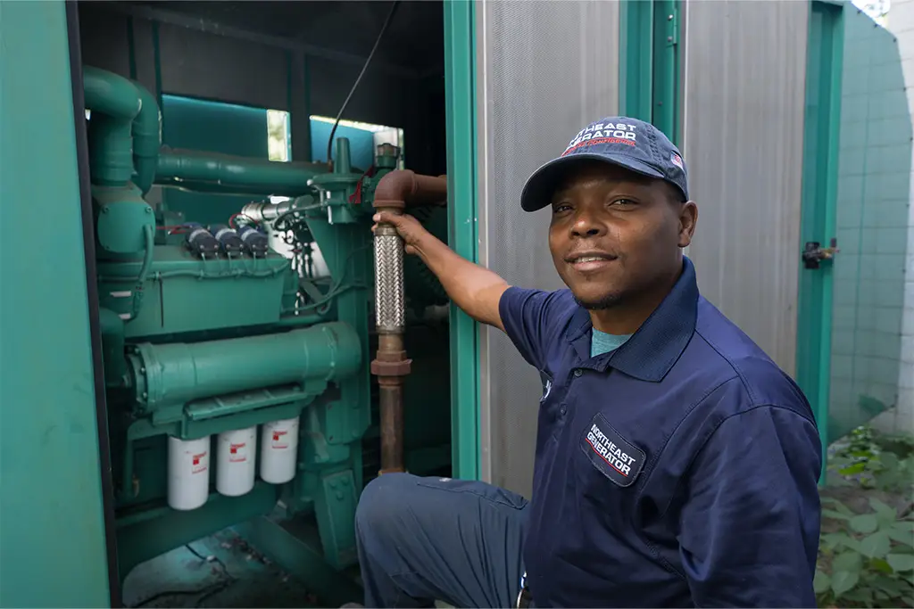 Northeast Generator technician working inside an industrial generator enclosure