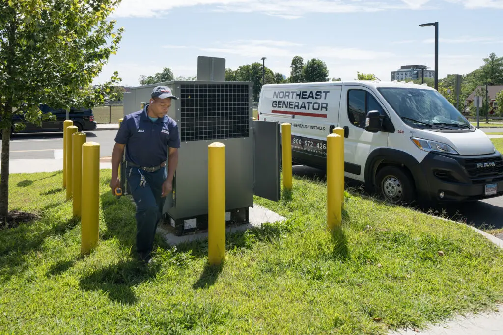 Northeast Generator technician walking from a commercial generator to a company service van